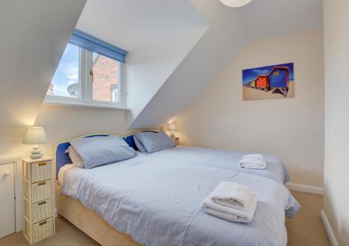 1 dormitorio con 1 cama con toallas en Corner Cottage, en Wells-next-the-Sea