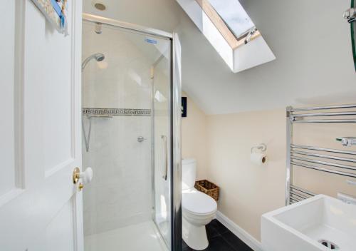 y baño con ducha, aseo y lavamanos. en Corner Cottage, en Wells-next-the-Sea