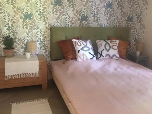 a bed with pillows on it in a bedroom at Mazurski Domek Brożówka 50 m od plaży in Brożówka