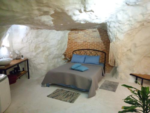 sypialnia z łóżkiem w kamiennej ścianie w obiekcie Cave house w Heraklionie