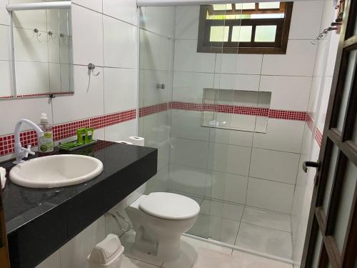 a bathroom with a shower and a toilet and a sink at Suíte na Vermelhinha do Tenório in Ubatuba