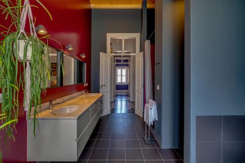 uma casa de banho com 2 lavatórios e uma parede vermelha em Best Luxury Boutique B&B Vista do Vale Tomar em Tomar