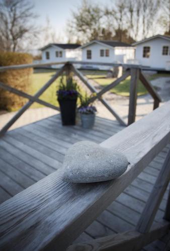 a rock sitting on top of a wooden bench at Kaptenshuset Hotell in Kivik