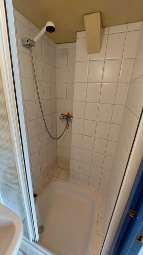 a bathroom with a shower with a tub and a sink at Holiday Home Achterbos in Sint-Oedenrode