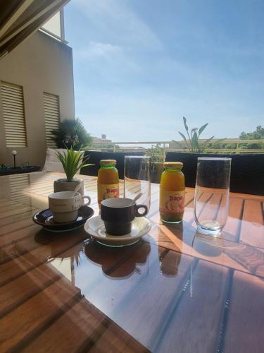 une table en bois avec des verres et une tasse à café dessus dans l'établissement Christelle, à Propriano