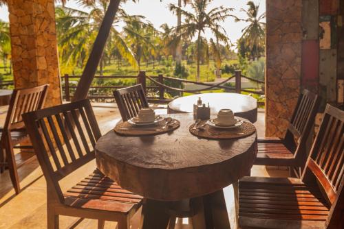 a wooden table and chairs on a patio at Moriá Eco Lodge in Icaraí