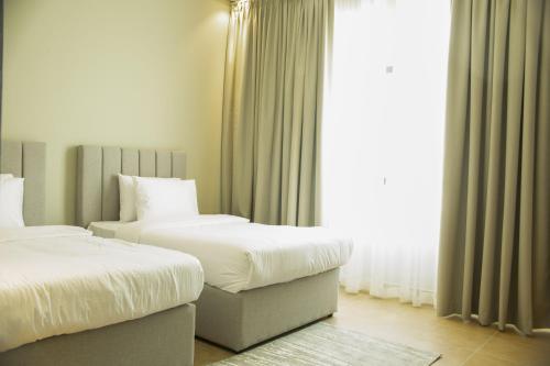 a hotel room with two beds and a window at Super OYO Capital O 111 Infinity Suites in Manama