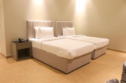 two beds sitting next to each other in a room at Super OYO Capital O 111 Infinity Suites in Manama