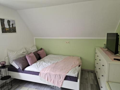 a small bedroom with a bed and a dresser at Tinyroom mit Ausblick in Königstein an der Elbe