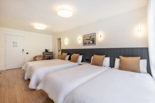 2 camas en una habitación de hotel con sábanas blancas en Granada Suites by Olala Homes, en Granada