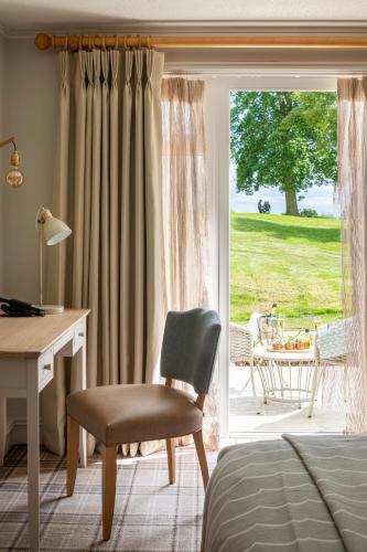 a bedroom with a desk and a chair in front of a door at Tewkesbury Park in Tewkesbury