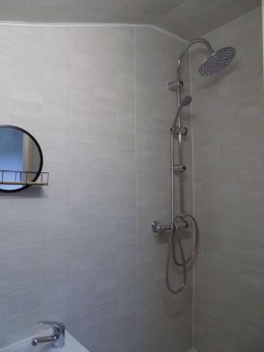a shower in a bathroom with a mirror at Vue du Jardin in Les Adjots