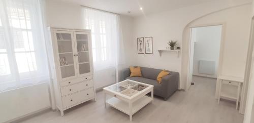 a living room with a gray couch and a white cabinet at Gemütliche Zweiraumwohnung in Ruhelage in Vienna