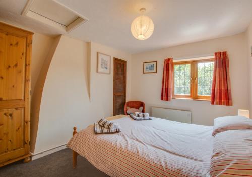 a bedroom with a large bed and a window at East Cottage in Corpusty