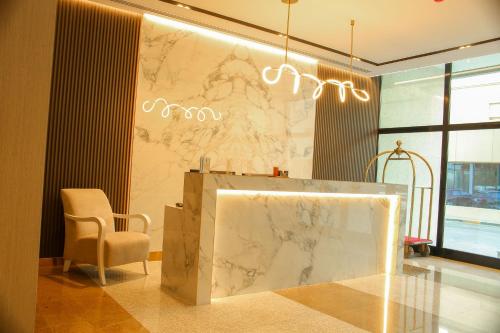 a lobby with a marble counter and a chair at Infinity Tower Suites WLL in Manama