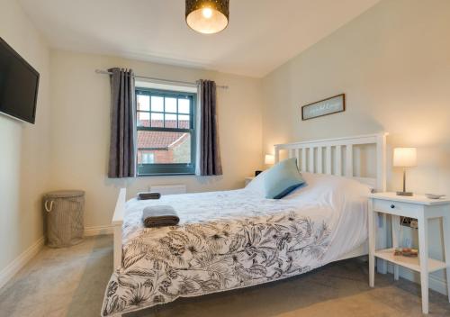 a bedroom with a white bed and a window at Ellivia House in Mundesley