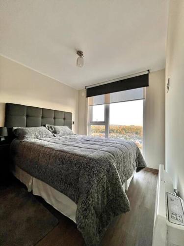Un dormitorio con una cama y una ventana grande. en Centro Temuco, en Temuco
