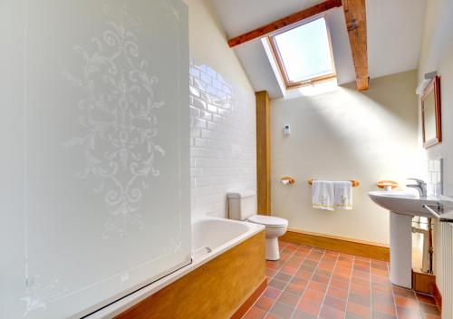 a bathroom with a tub and a sink at Farm Cottage in Sidestrand