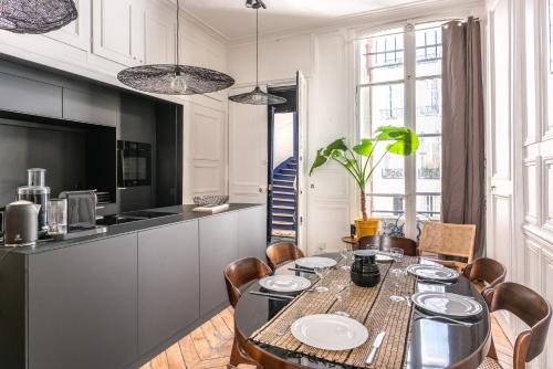 une cuisine et une salle à manger avec une table et des chaises dans l'établissement Outstanding Parisian flat in heart of Paris center, à Paris