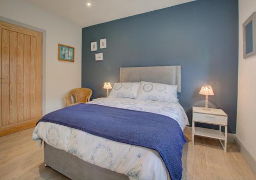 a bedroom with a large bed with a blue wall at Field View in Hindolveston