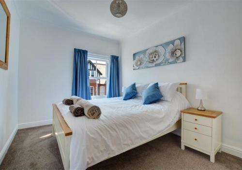 a bedroom with a white bed with blue pillows at Flat 2 in Cromer