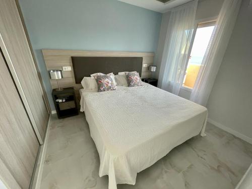 ein Schlafzimmer mit einem großen weißen Bett mit zwei Kissen in der Unterkunft Benal Beach Sun in Benalmádena