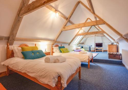 1 dormitorio con 2 camas en un ático en Flaxmans Farmhouse en Roughton