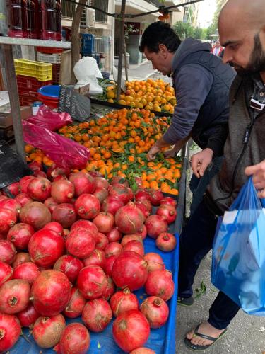 two men looking at a display of apples at a market at ARIS Piraeus- Sailor's friend in Piraeus