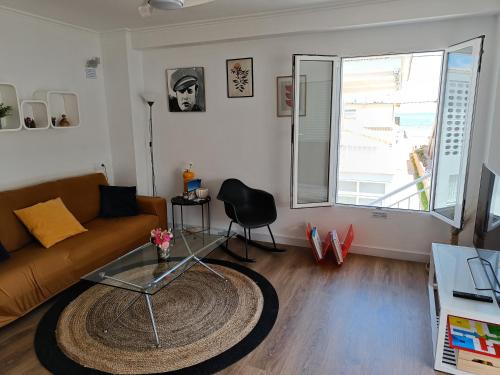 a living room with a couch and a glass table at Apartamento con VISTAS AL MAR in Oliva