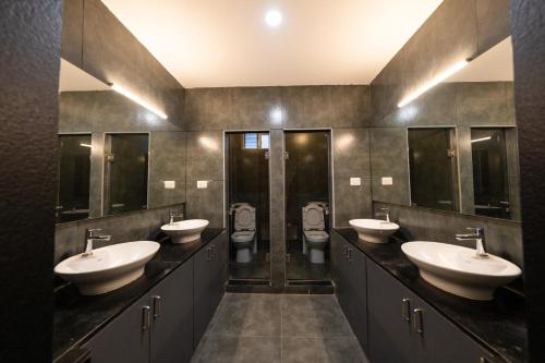 ein Badezimmer mit 3 Waschbecken und 2 WCs in der Unterkunft TAG HOTELS in Irugūr