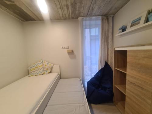 Una pequeña habitación con una cama y una ventana. en Jūros perlas, en Palanga