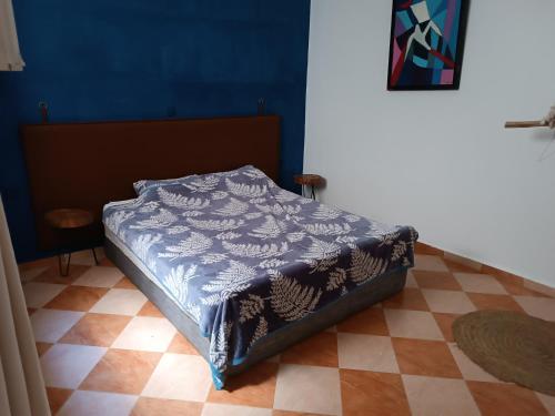 a bed in a bedroom with a blue wall at Borj2 in Essaouira