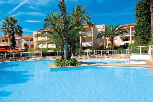une grande piscine avec des palmiers en face d'un bâtiment dans l'établissement Cosy 1 bed in Golfe Juan - tennis * pool & beach!, à Vallauris