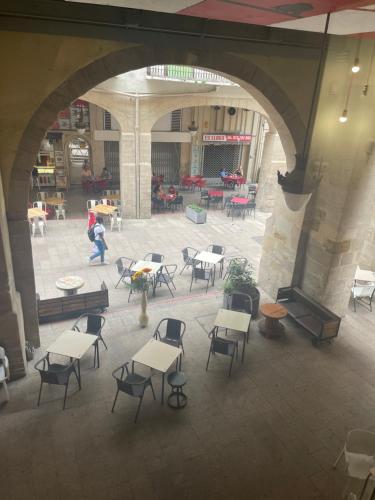 an empty courtyard with tables and chairs in a building at La Impronta Relax in Lleida