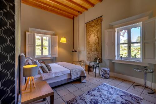 ein Schlafzimmer mit einem Bett und zwei Fenstern in der Unterkunft Best Luxury Boutique B&B Vista do Vale Tomar in Tomar