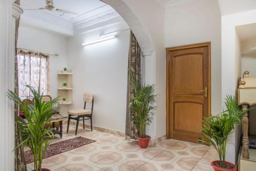a hallway with potted plants and a wooden door at Host Jatin Kasauli Pine Villa 7oI827o7o3 in Kasauli