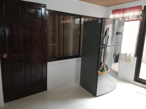 a kitchen with a stainless steel refrigerator in a room at Central 3 Bedroom Quepos Home in Quepos