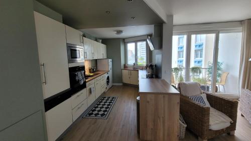 une cuisine avec des armoires blanches et un comptoir dans l'établissement La Méridienne des Dunes, à Malo-les-Bains