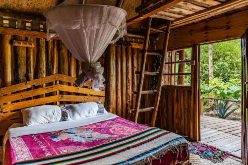 Kalitusi Nature Resort في Fort Portal: غرفة نوم بسرير وسلم في كابينة