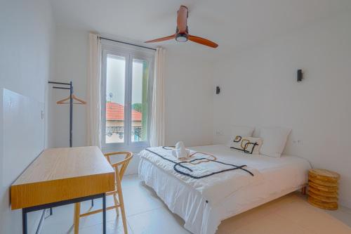 NOCNOC - L'Amarelo - Charmant T4 avec terrasse au calme في مونبلييه: غرفة نوم بيضاء بها سرير ونافذة