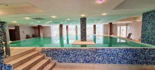 a swimming pool with blue tiles in a building at Résidence Goélia Les Gorges de la Truyère in Entraygues-sur-Truyère