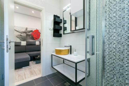 een badkamer met een douche, een wastafel en een glazen deur bij Apartman Mimi in Baška Voda