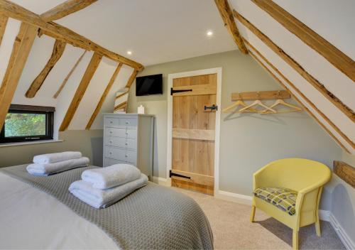 Keepers Cottage في Panxworth: غرفة نوم بسريرين وكرسي