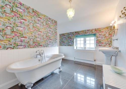 a bathroom with a tub and a sink at Knapton Hall Cottage in Knapton