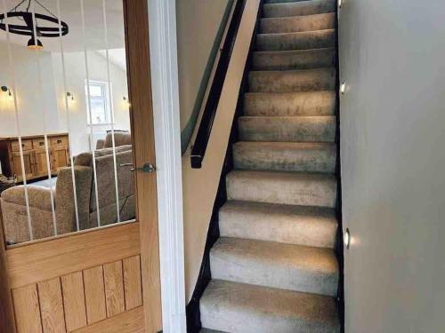 a staircase in a home with a wooden door at The Old Station House by Holiday Heim in Lytham St Annes