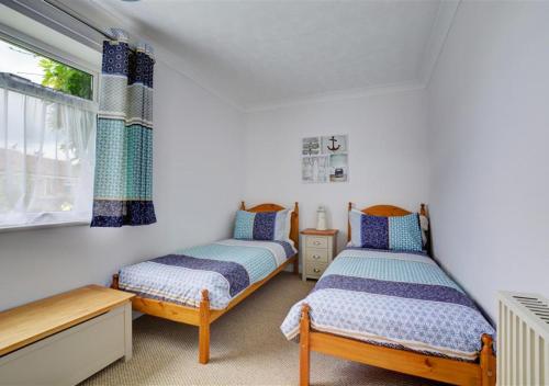 - une chambre avec 2 lits et une fenêtre dans l'établissement Lane End Cottage, à Snettisham