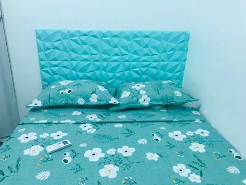 1 cama con edredón verde y almohadas con cabecero azul en La casita Verde, en Beberibe