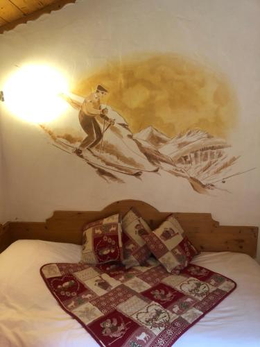 a bedroom with a painting of a man on a boat at Hôtel la Kinkerne in Morzine
