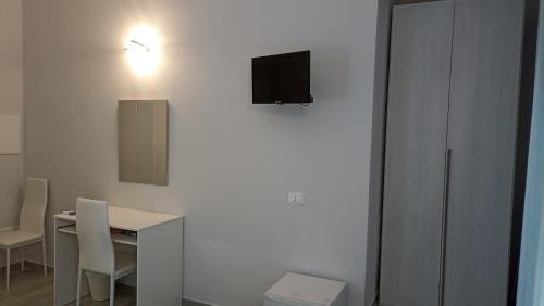 a white room with a table and a television on a wall at Le vie del centro in Sciacca