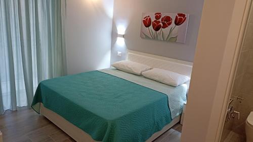 a small bedroom with a bed with a green bedspread at Le vie del centro in Sciacca